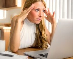 woman on computer looking frustrated