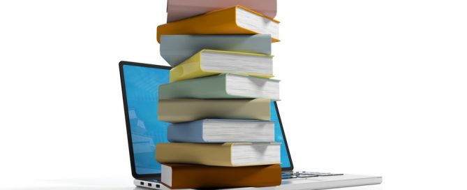 Books stacked on a laptop
