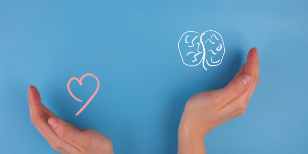 hands cupping drawing of heart and brain
