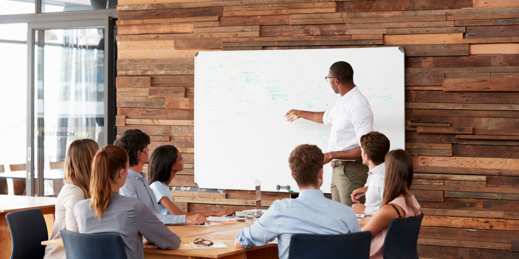 Man pointing at white board, making presentation